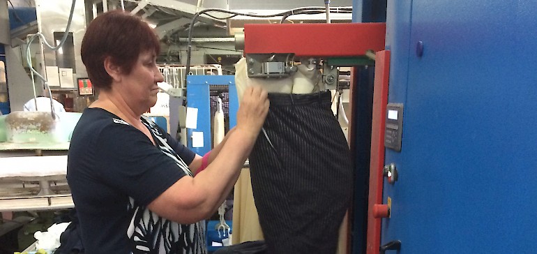 Eine Mitarbeiterin bearbeitet eine Hose