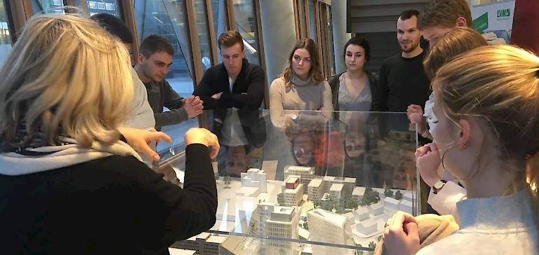 Eine Mitarbeiterin zeigt anhand eines Modells die verschiedenen Gebäude der LVM